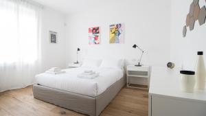 a white bedroom with a white bed and a desk at Italianway - De Cristoforis 12 Flat in Milan