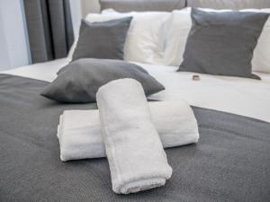 サヴォーナにあるMy Luxury Suites - Standardのベッドの上に座るタオルの山