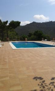 a swimming pool with a tile floor and mountains in the background at RIVIERA in Benicàssim