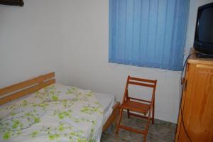 a bedroom with a bed and a chair and a television at Casa cu Castan in Eforie Nord