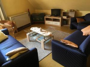 a living room with two blue chairs and a table at Haus Rübezahl in Helminghausen