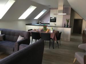 a dining room with a table and a kitchen at oyenkerke-loft in De Panne