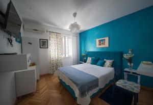 a blue bedroom with a bed and a tv at ASTAKOS apartments Budva in Budva