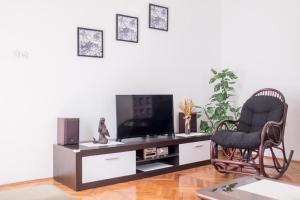 a living room with a chair and a television at Apartment Sv. Marak in Risika