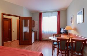 Habitación con mesa, sillas y cocina. en Penzion Fan en Karlovy Vary