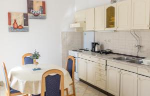 a kitchen with white cabinets and a table and a sink at Apartment Sv. Marak in Risika