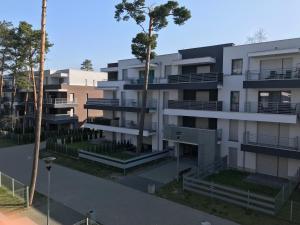 apartamentowiec z balkonem i drzewem w obiekcie Morskie zacisze 22 w Pogorzelicy
