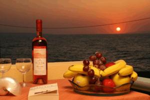 un bol de fruta en una mesa con una botella de vino en Nautilus Apartments, en Sissi