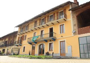 ein gelbes Gebäude mit Balkon an der Seite in der Unterkunft Ca d'Pinin in Albugnano 