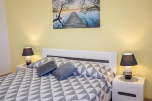 a bedroom with a bed with two lamps on tables at Apartment Sv. Marak in Risika