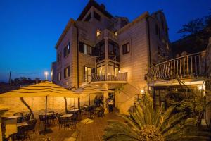 ドゥブロヴニクにあるヴィラ ダルドの建物の前にテーブルと傘