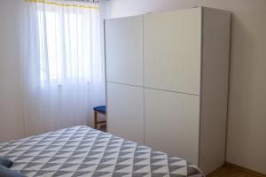 a bedroom with a white cabinet and a bed at Apartment Sv. Marak in Risika