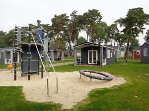 een speeltuin met een glijbaan en een speelstructuur bij Lodge 4 personen camping de Molenhof in Reutum