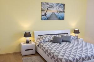 a bedroom with a bed and two lamps on a night stand at Apartment Sv. Marak in Risika