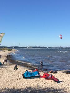 a group of people on a beach flying kites at Laboe-Hafen in Laboe