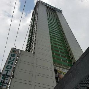 a tall building with a sign on the side of it at Eurotel Vivaldi Araneta in Manila