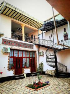 un bâtiment avec un escalier et une cour fleurie dans l'établissement Hamida, à Samarcande