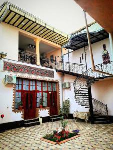 a building with a staircase and a courtyard with flowers at Hamida in Samarkand