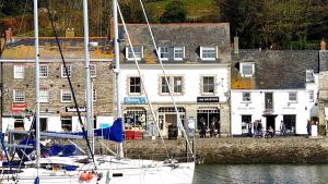 a boat is docked in a harbor with buildings at Padstow Escapes - Pajar Luxury Penthouse Apartment in Padstow