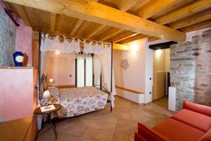 een slaapkamer met een bed en een bank in een kamer bij Il Nido Delle Rondini in Testico