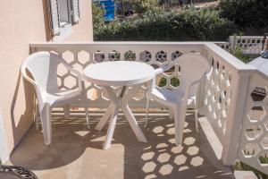 two white chairs and a table on a balcony at Apartment Sv. Marak in Risika