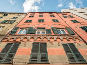 ein hohes rotes Backsteingebäude mit Fensterläden in der Unterkunft My Luxury Suites - Standard in Savona