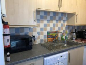 a kitchen counter with a sink and a microwave at NEW Super 2BD Flat near Dalkeith Town Centre in Dalkeith