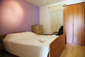 a bedroom with a bed and a wooden cabinet at Apartments Tonia br. 1 in Zavalatica