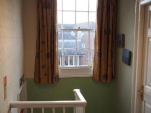 a window in a room with a crib and a window at The Coach House in Canterbury
