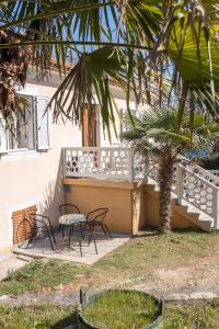 a patio with two chairs and a table in front of a building at Apartment Sv. Marak in Risika