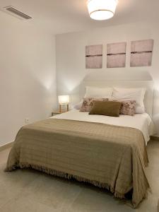 sypialnia z dużym łóżkiem w białym pokoju w obiekcie Diamond Apartments Puerto De Malaga w Maladze