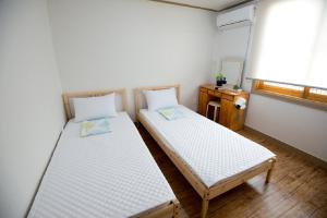 Ένα ή περισσότερα κρεβάτια σε δωμάτιο στο Jeju Masil Guesthouse