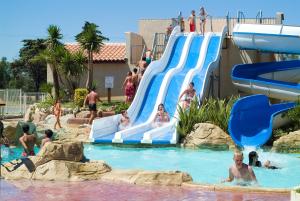 a group of people on a water slide at a water park at Domaine Les Mûriers in Vendres-Plage