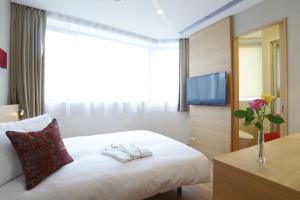 a hotel room with a bed and a tv at Red Roof Inn & Suites Osaka Namba Nipponbashi in Osaka