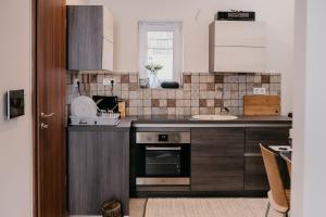 a kitchen with a sink and a stove top oven at JAM Luxury Apartment in Győr