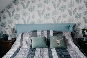 a bedroom with a bed with a blue headboard at JAM Luxury Apartment in Győr