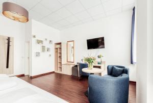 a living room with two blue chairs and a table at Pallas Hotel in Darmstadt