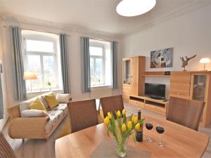 a living room with a couch and a table with flowers at Excellent Villa in Borstendorf with Garden in Grünhainichen