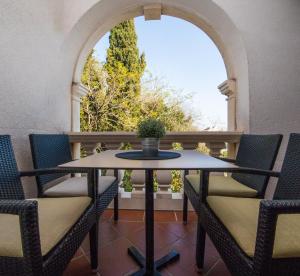 a table and chairs on a balcony with a window at Villa Dard in Dubrovnik