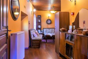 a kitchen with yellow walls and a living room at Petrino Guesthouse in Kalabaka