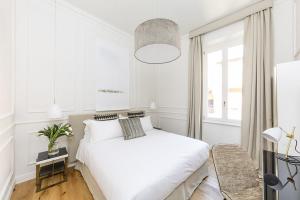 a white bedroom with a white bed and a window at Parisii Luxury Relais Rome-Fontana di Trevi in Rome