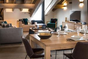 a living room with a wooden table and chairs at Le C by Alpine Residences in Courchevel