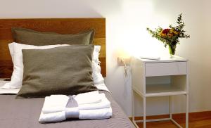 a bed with a white towel and a vase of flowers at Maqueda331 in Palermo