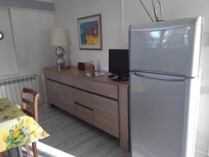 La cuisine est équipée d'un réfrigérateur et d'une armoire en bois. dans l'établissement domaine de Castencau, à Saint-Louis-de-Montferrand