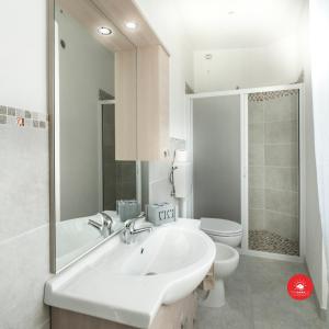 a white bathroom with a sink and a toilet at 36 Holidays Home in La Spezia
