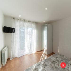 a bedroom with a large window with white curtains at 36 Holidays Home in La Spezia