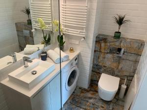 a bathroom with a sink and a washing machine at AGIHOME Rajska 3 Apartments in Krakow