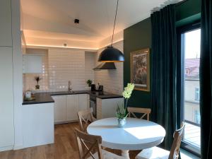 uma cozinha e sala de jantar com uma mesa branca em AGIHOME Rajska 3 Apartments em Cracóvia