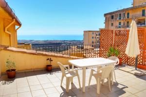 a balcony with a table and chairs and an umbrella at B&B Anita in Agrigento
