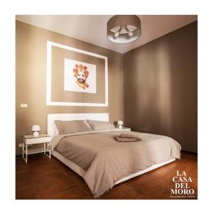 1 dormitorio con 1 cama y una pintura en la pared en La Casa del Moro, en Palermo